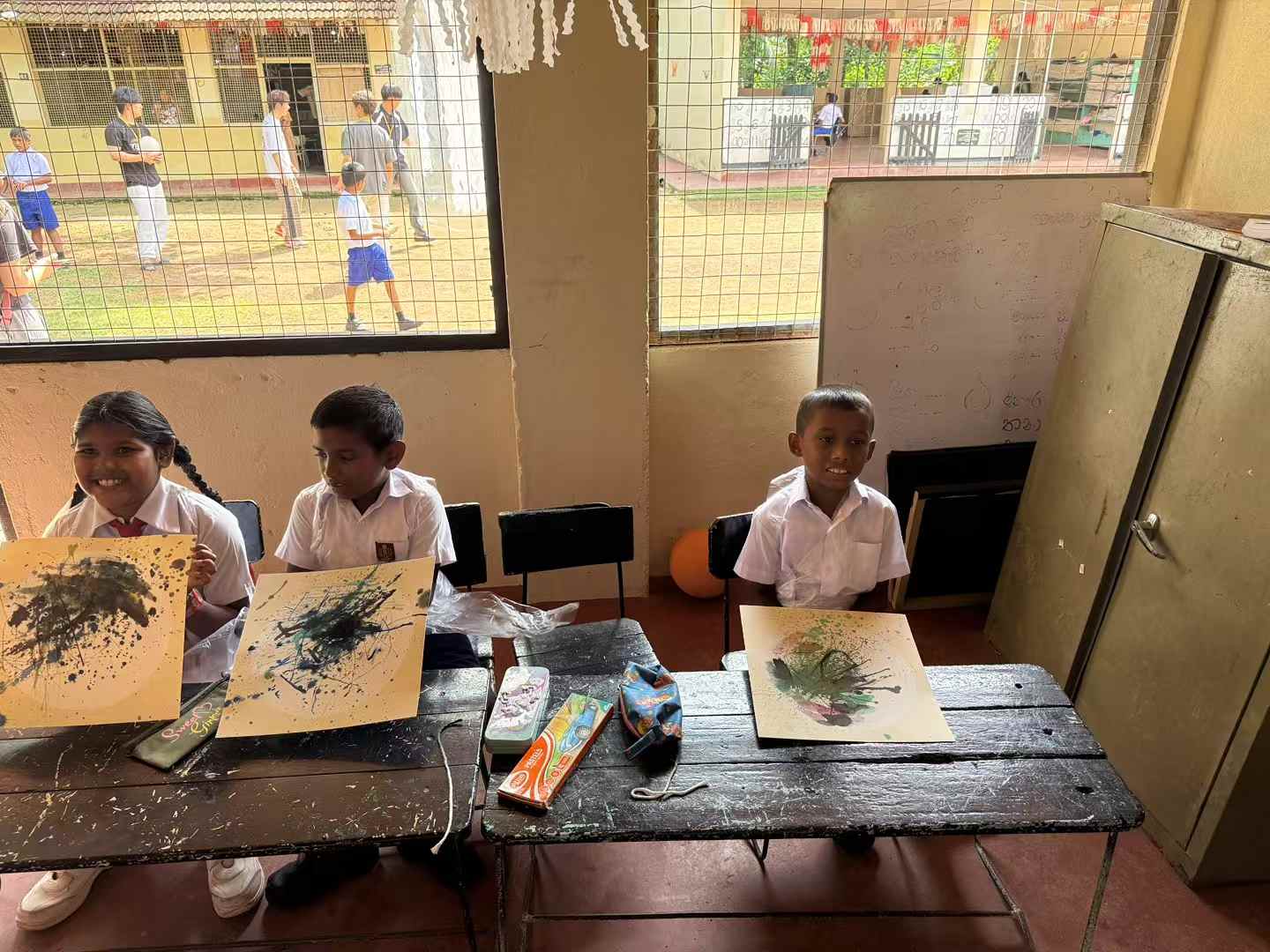 Students showing art projects in a Sri Lanka classroom